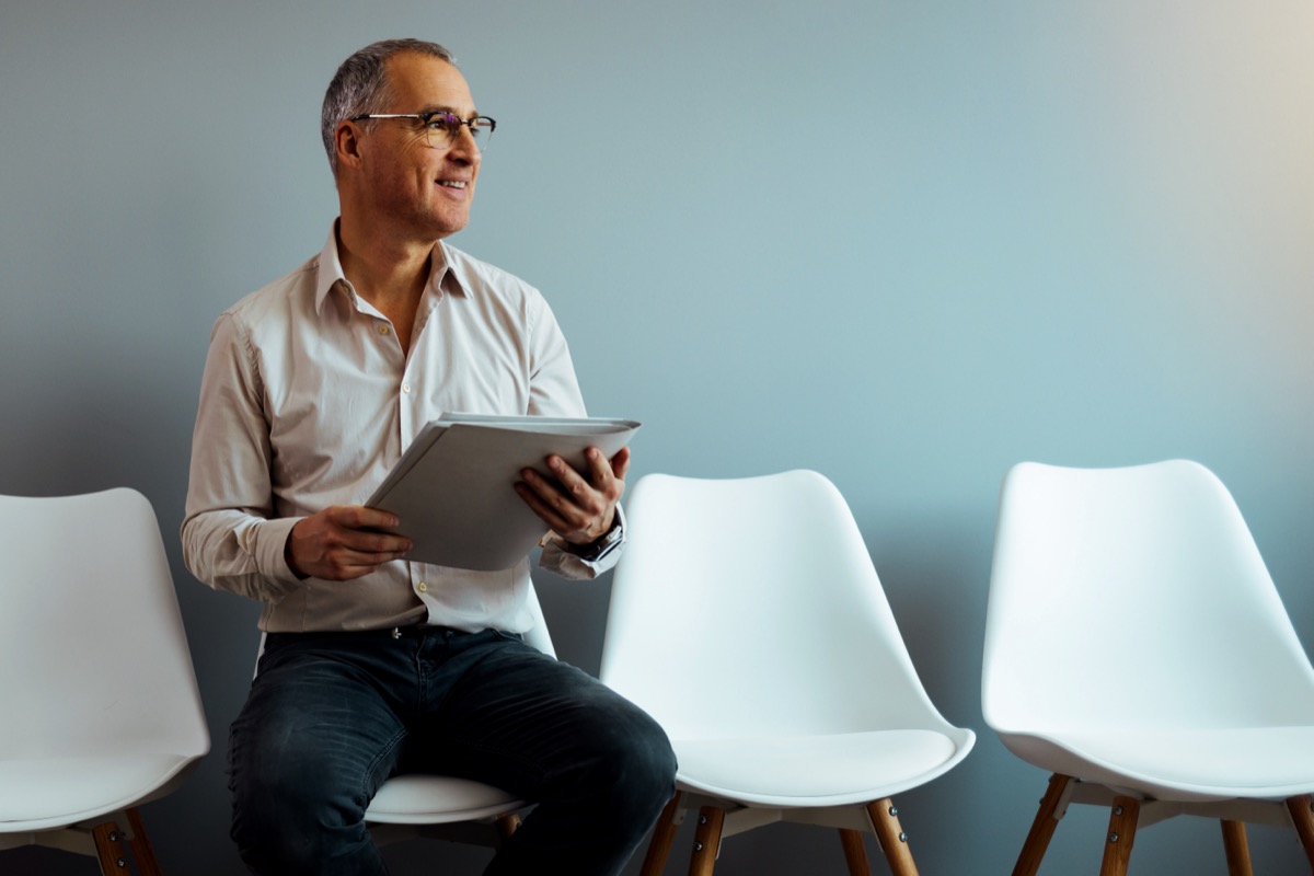 A mature man sitting in a waiting room